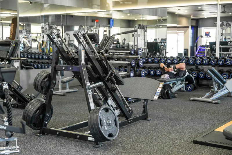 Plate-loaded machines in front of the dumbbell wall